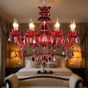 Lustre en cristal rouge éclairé dans une chambre classique au-dessus d'un lit