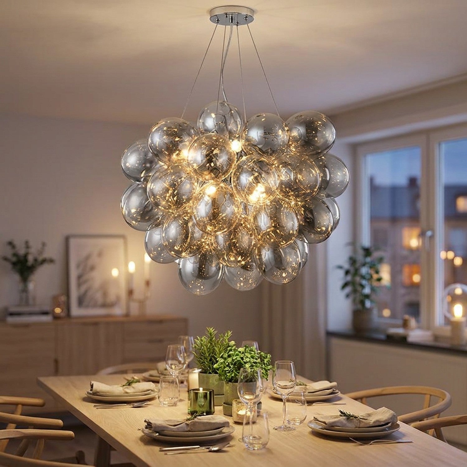 Lustre grappe boules en verre suspendu au-dessus d'une table à manger lumière douce ambiance nordique