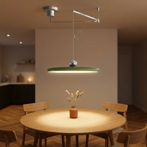 Lustre LED pivotant vert bras déporté au-dessus d'une table à manger dans une salle à manger nordique