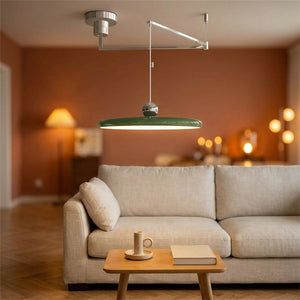 Lustre LED pivotant vert bras déporté dans un salon cosy aux murs terracotta