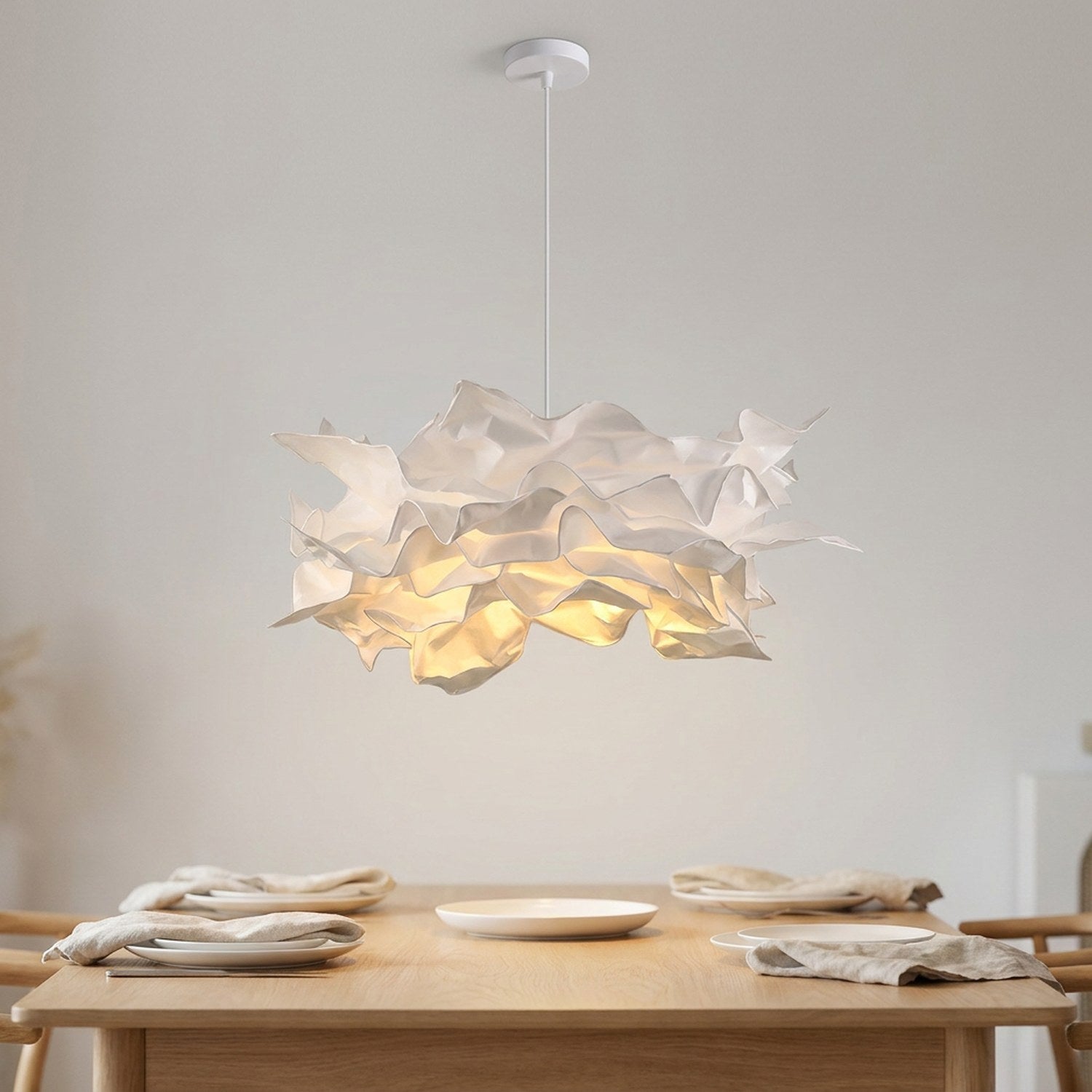 Lustre nuage en papier DIY blanc allumé suspendu au plafond d'une salle à manger scandinave