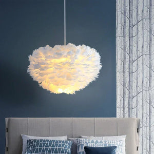 Lustre en plumes blanches suspendu dans une chambre avec tête de lit grise