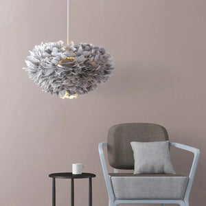 Lustre en plumes grises suspendu près d'un fauteuil gris