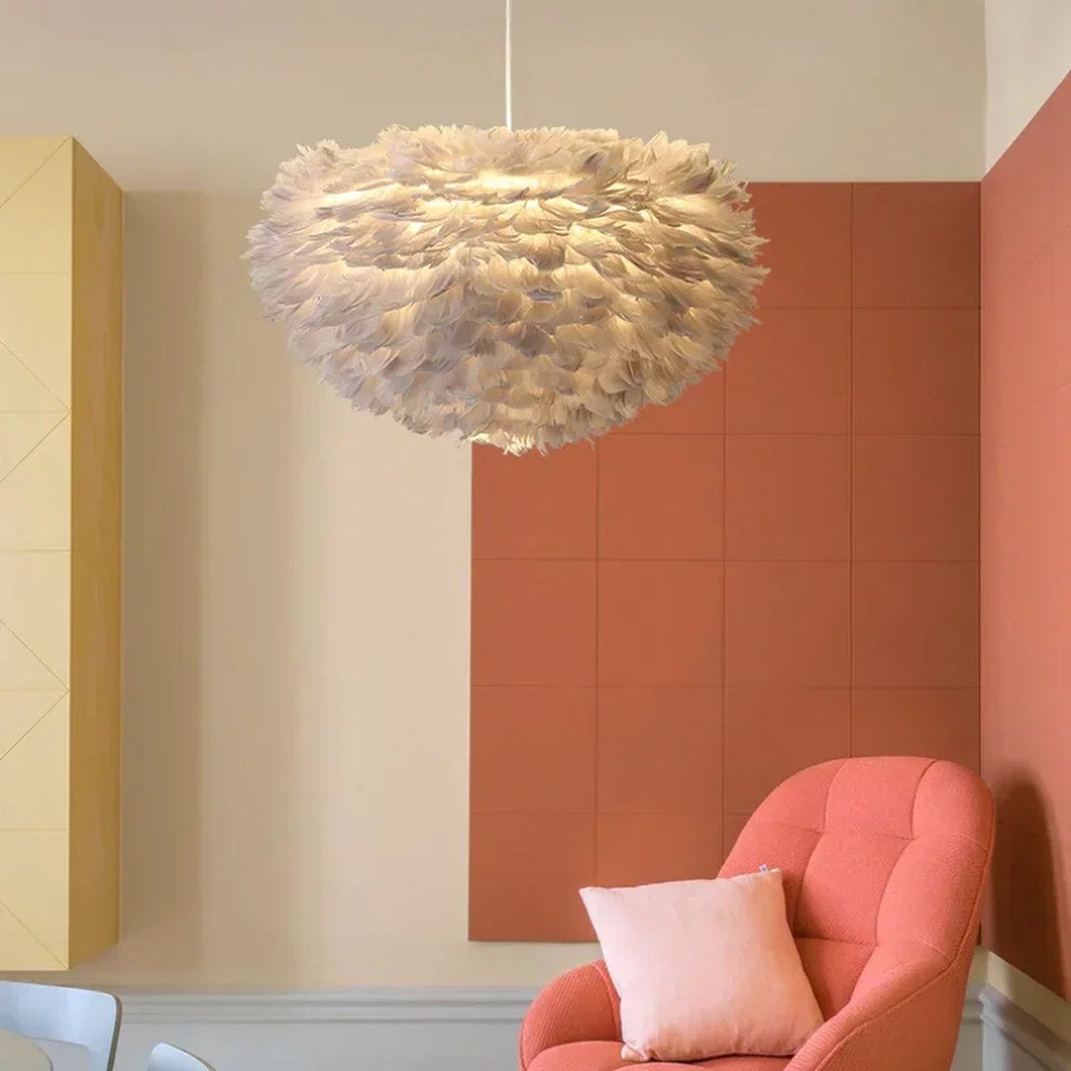 Lustre en plumes grises suspendu dans un salon aux tons terracotta