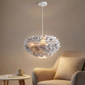 Lustre suspendu en plumes grises diffusant une lumière chaude dans un salon cocooning