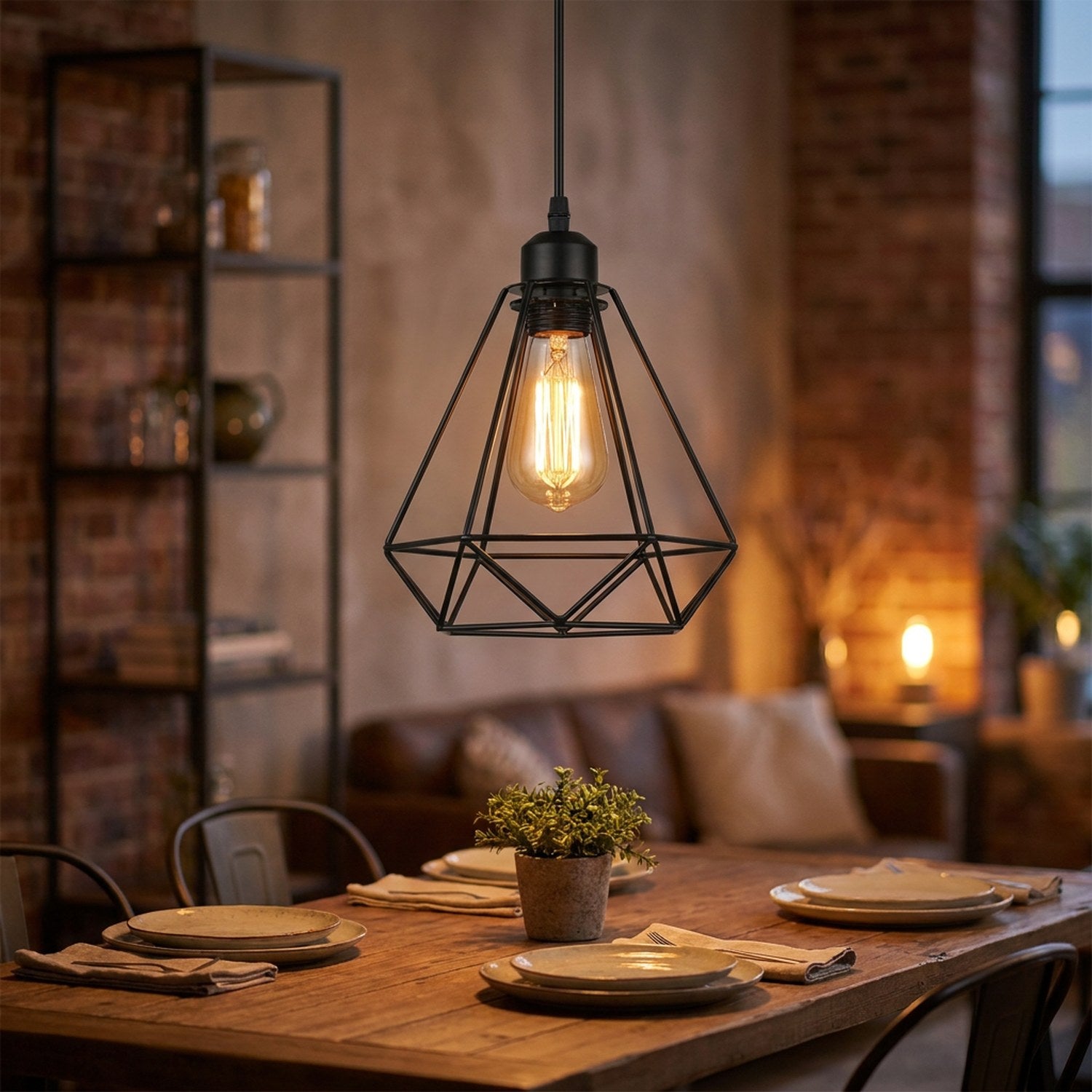 Suspension industrielle cage diamant en métal noir avec ampoule Edison allumée au-dessus d'une table