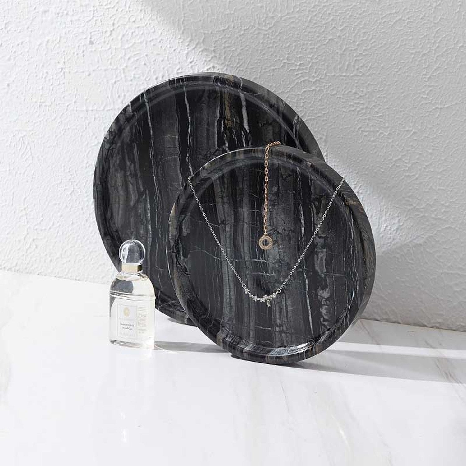 Plateaux ronds en marbre noir — comparaison tailles 15 cm et 20 cm