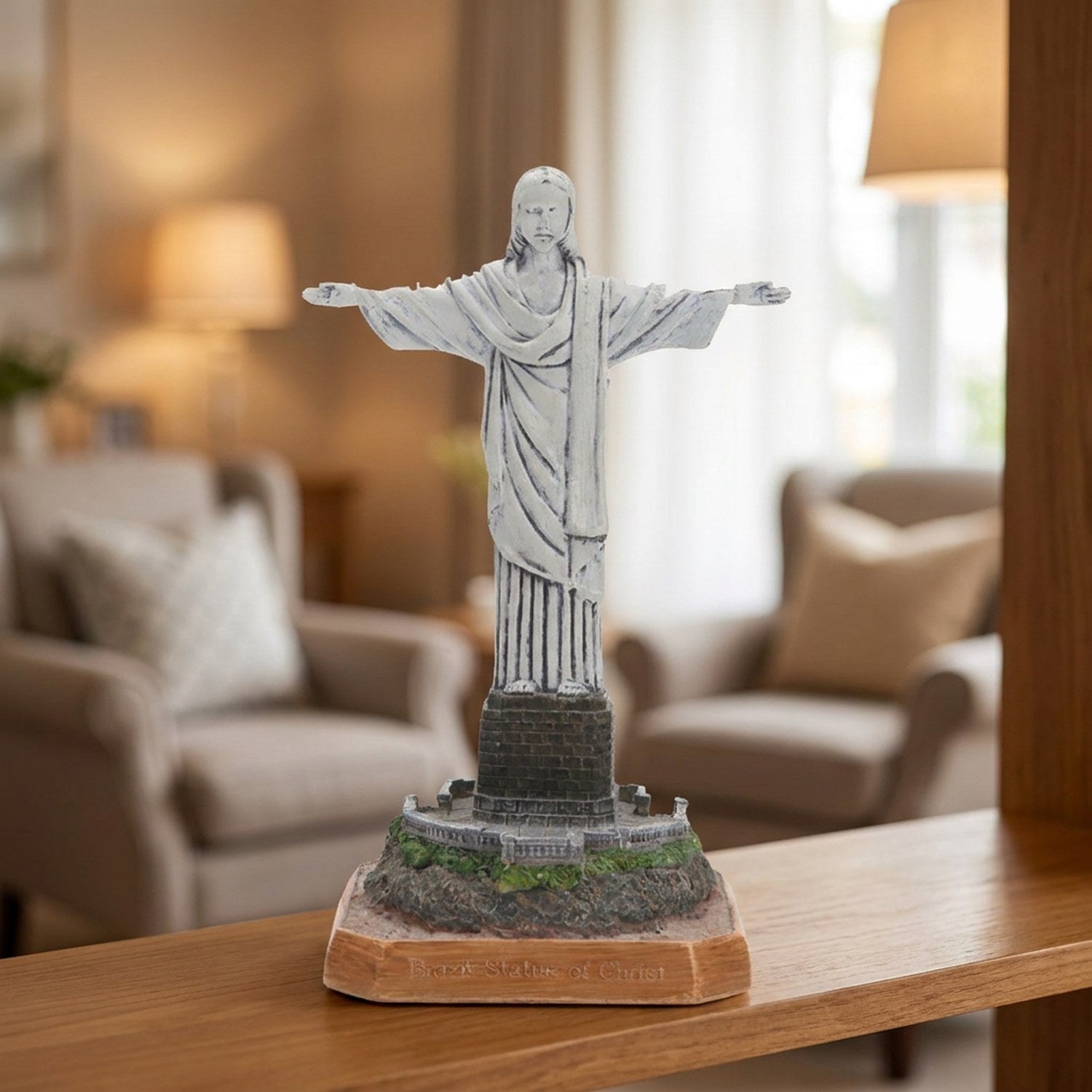 Statue du Christ rédempteur en résine grise posée sur une étagère en bois dans un salon chaleureux