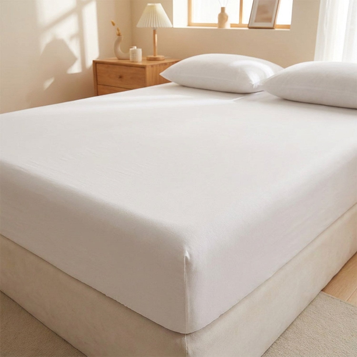 Drap housse blanc délavé avec bandes élastiques installé sur un matelas dans une chambre lumineuse