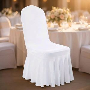 Housse de chaise blanche à jupe plissée dans une salle de réception avec table dressée
