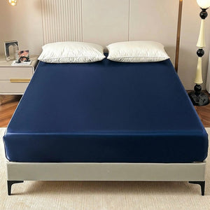 Drap-housse satin bleu marine élastique installé sur un lit dans une chambre chaleureuse