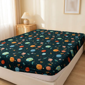 Drap housse imprimé cosmos avec fusées et planètes colorées sur un lit fait dans une chambre chaleureuse