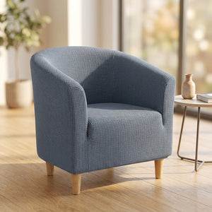 Housse de fauteuil cabriolet extensible grise sur un fauteuil club dans un salon lumineux
