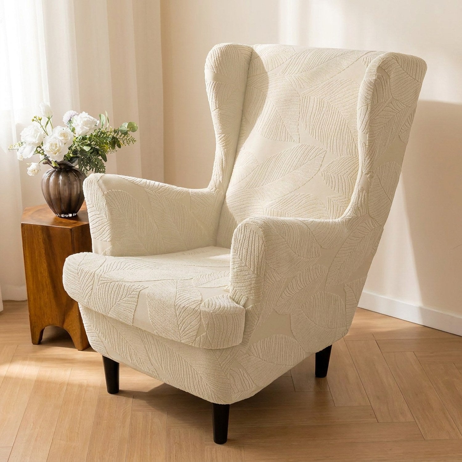 Fauteuil bergère habillé d'une housse crème à motif feuilles jacquard dans un salon lumineux