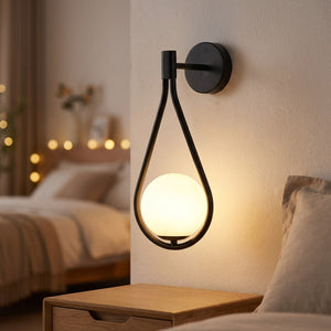 Applique murale boule de verre noire au design nordique diffusant une lumière chaude dans une chambre
