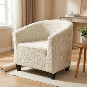 Fauteuil club habillé d'une housse crème à motif feuilles jacquard dans un salon lumineux