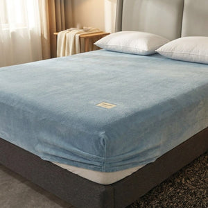 Drap-housse flanelle bleu clair sur un lit fait dans une chambre chaleureuse