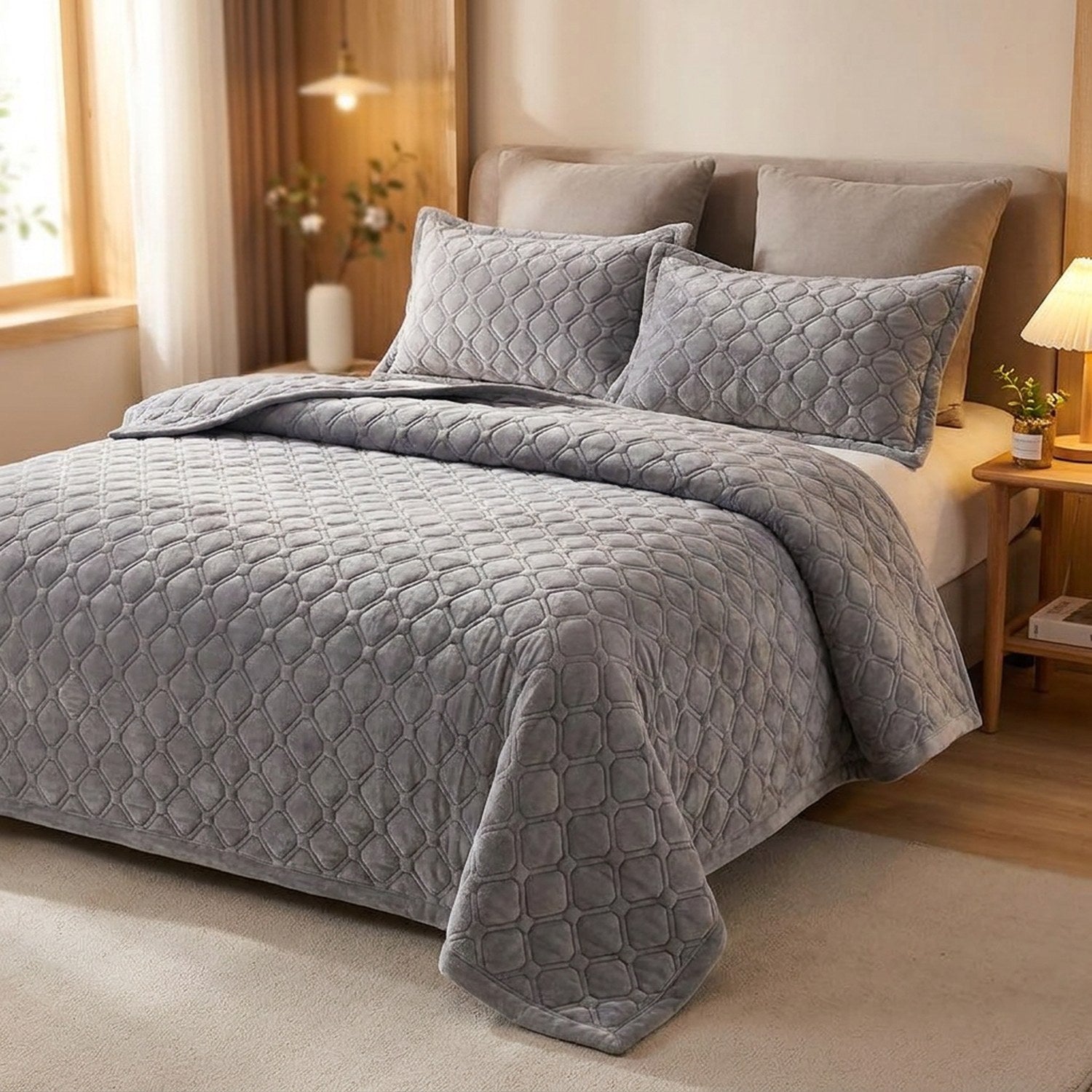 Couvre-lit matelassé gris avec taies assorties sur un lit dans une chambre lumineuse