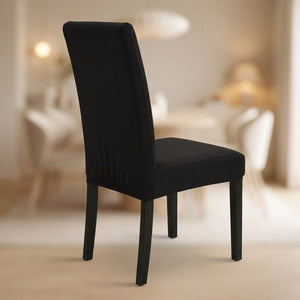 Housse de chaise noire extensible et imperméable installée sur une chaise de salle à manger