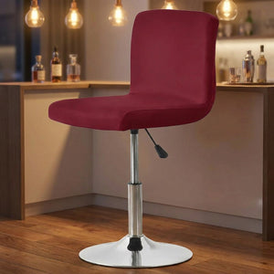 Housse de chaise colorée tendue sur un tabouret de bar pivotant dans une cuisine lumineuse