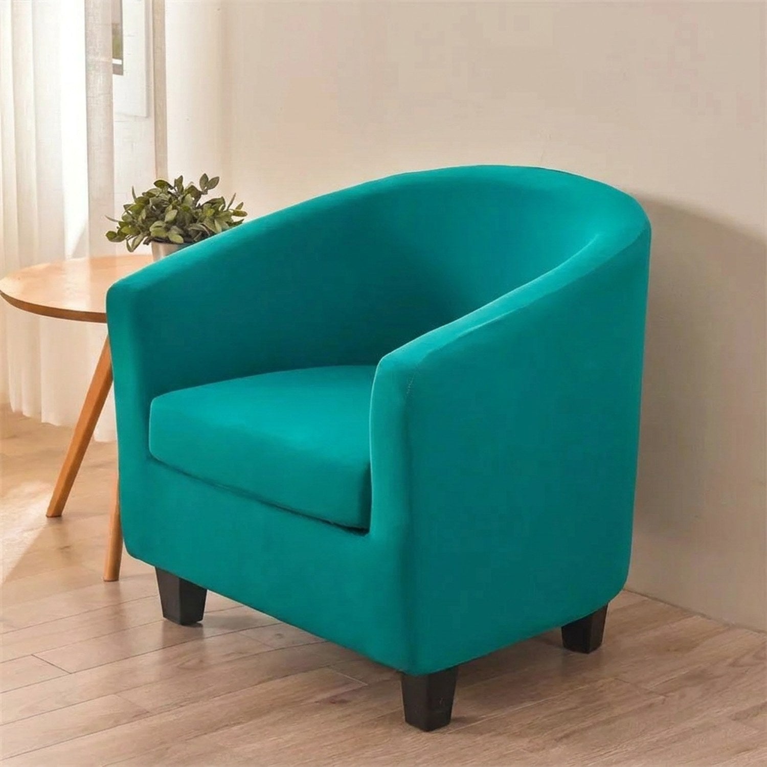 Fauteuil club habillé d'une housse extensible en coloris uni dans un salon lumineux et chaleureux