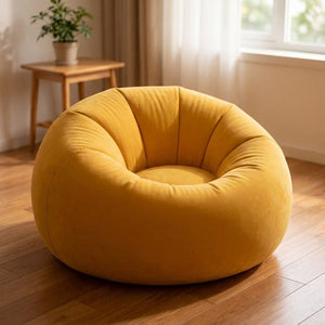 Pouf fauteuil gonflable rond jaune moutarde posé au sol dans un salon lumineux