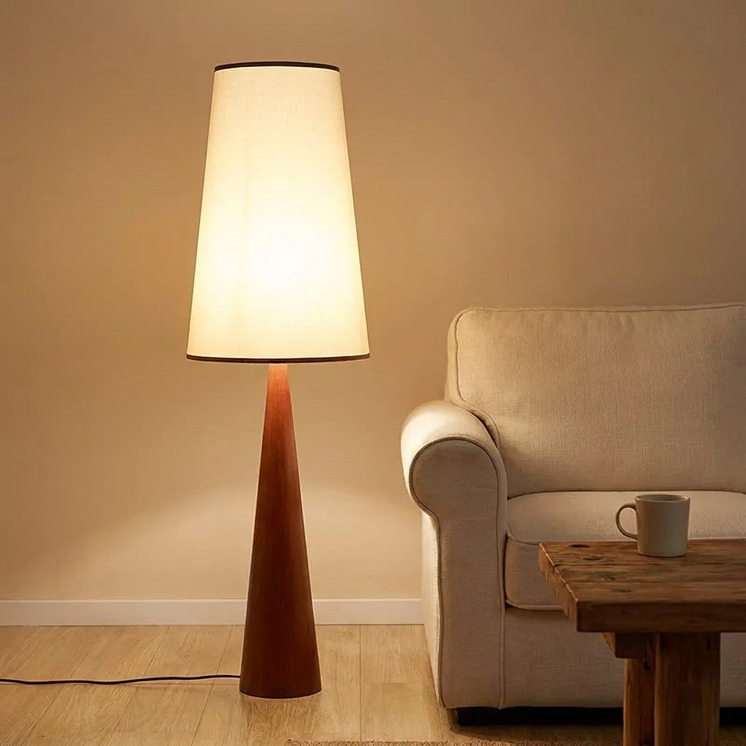 Lampadaire moderne en bois roux avec abat-jour en tissu allumé dans un salon