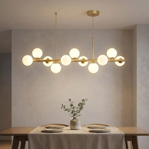 Lustre doré à globes de verre opalin allumé au dessus d'une table à manger dressée