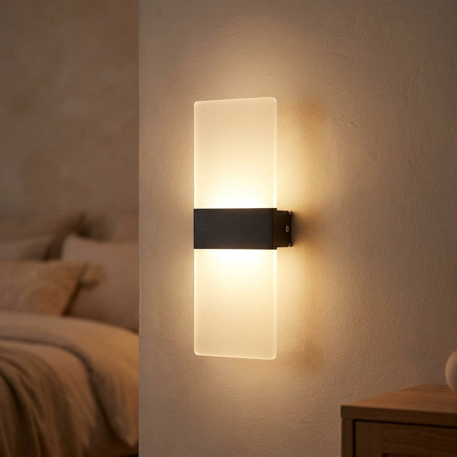 Applique murale LED noire au panneau acrylique diffusant une lumière chaude haut et bas sur un mur