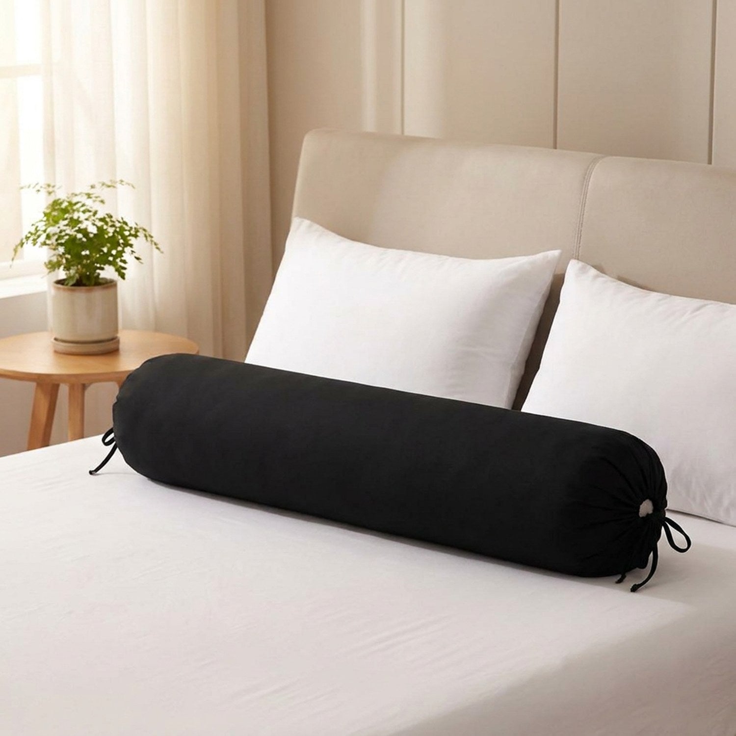 Traversin cylindrique noir posé sur un lit fait dans une chambre chaleureuse