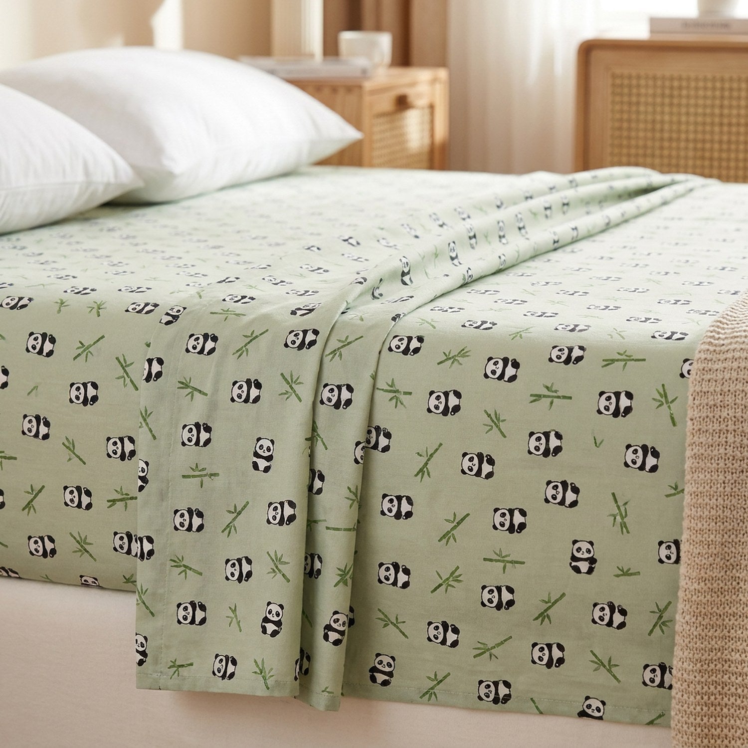 Drap plat en coton motif panda posé sur un lit fait dans une chambre chaleureuse