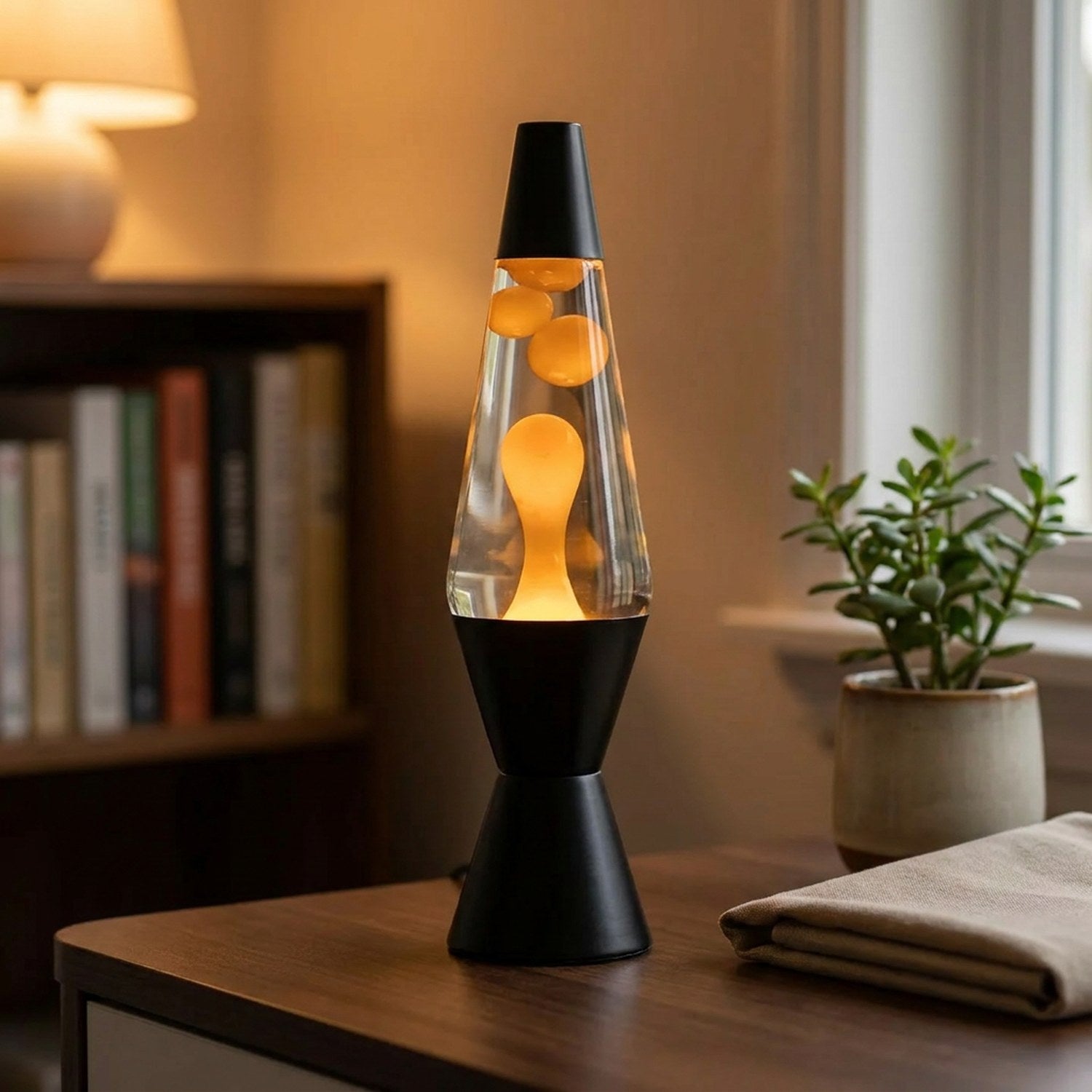 Lampe à lave noire allumée avec bulles orange en mouvement sur un bureau