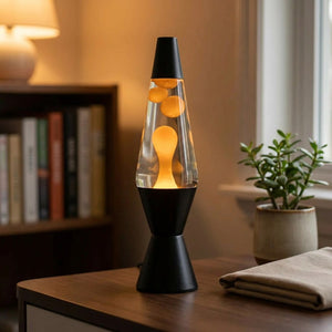 Lampe à lave noire allumée avec bulles orange en mouvement sur un bureau