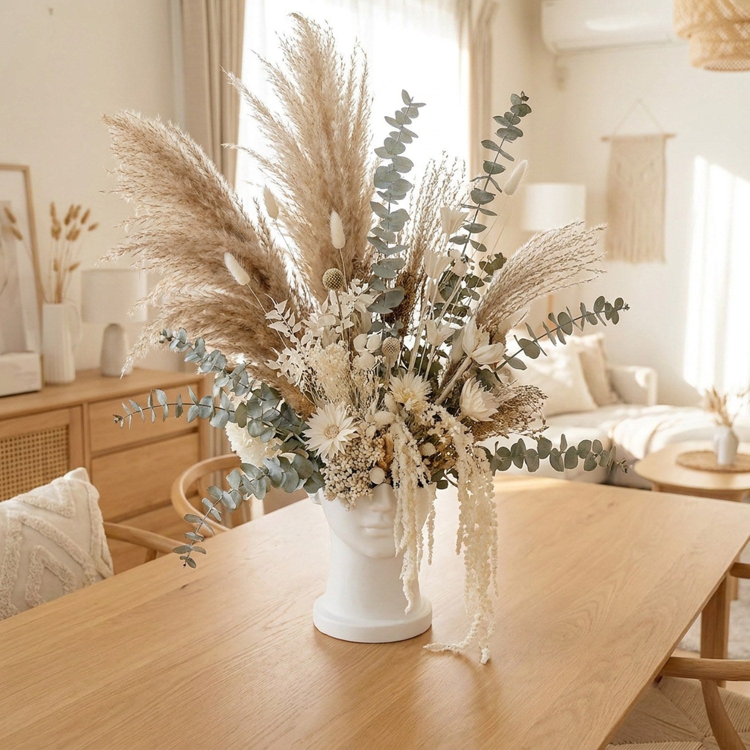 Vase tête grecque en résine blanche avec arrangement luxuriant de pampa et fleurs séchées sur table en bois, salon scandinave