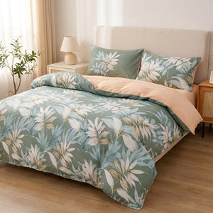 Parure de lit aux feuilles tropicales vertes installée sur un lit fait dans une chambre lumineuse et naturelle