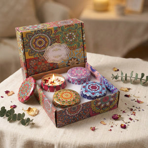 Coffret de quatre bougies parfumées en pots bohème ornés de fleurs séchées sur une table chaleureuse