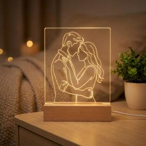 Lampe personnalisée avec un dessin au trait gravé illuminé posée sur un socle en bois dans un intérieur chaleureux