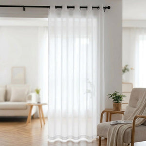 Voilage blanc translucide à œillets suspendu à une fenêtre de salon lumineux