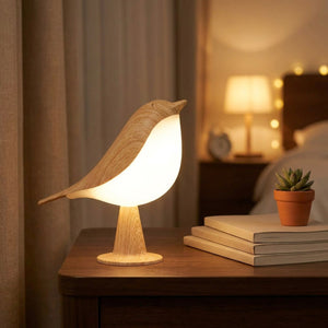 Lampe tactile en forme d'oiseau posée sur une table de chevet avec lumière chaude allumée