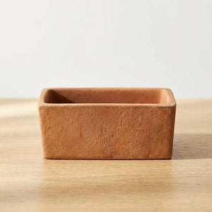 Pot de fleur rectangulaire en terre cuite avec succulente sur une surface en bois