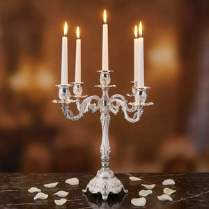 Chandelier 5 bras argenté baroque avec bougies allumées sur marbre