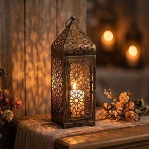 Lanterne marocaine ajourée en métal bronze avec bougie allumée projetant des motifs sur le mur