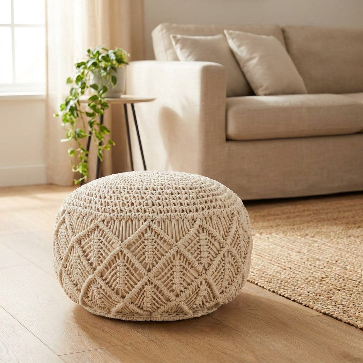 Pouf en macramé rond de couleur crème posé au sol dans un salon bohème lumineux près d'un canapé