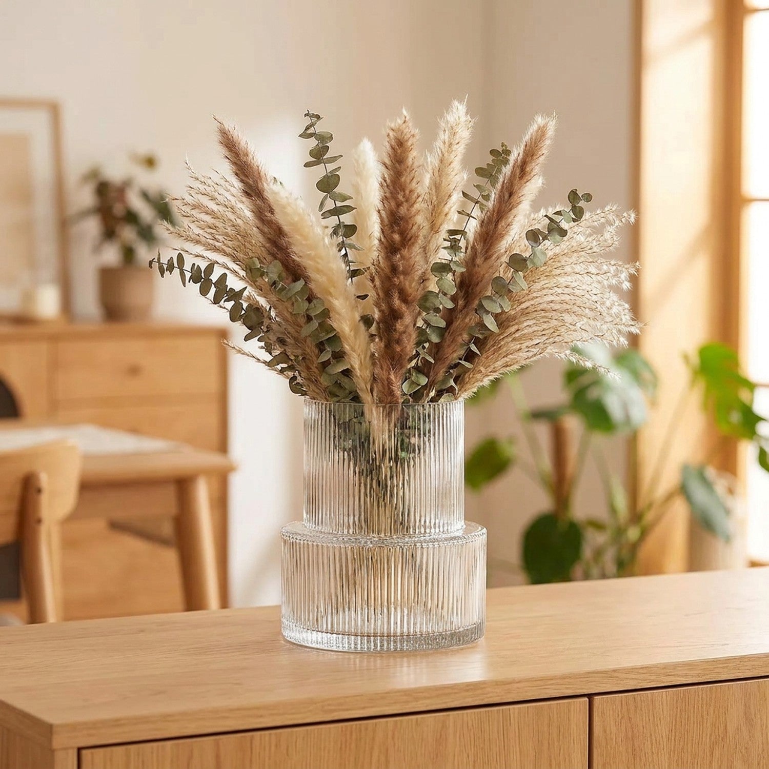 Vase en verre rayé transparent à côtes verticales avec pampa et eucalyptus dans un salon contemporain