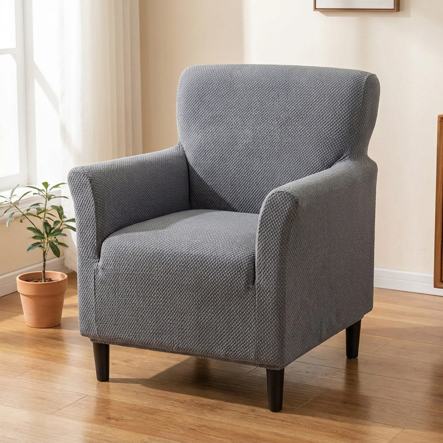 Fauteuil une place habillé d'une housse jacquard grise ajustée dans un salon lumineux
