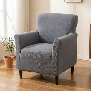 Fauteuil une place habillé d'une housse jacquard grise ajustée dans un salon lumineux