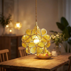Suspension fleur en verre ambré style Tiffany avec monture laiton allumée au-dessus d'une table de salle à manger