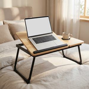 Table de lit pliable en bambou avec plateau incliné et ordinateur portable posée sur un lit lumineux