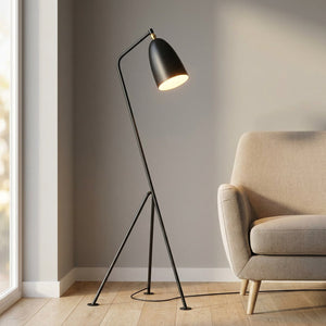 Lampadaire trépied noir au design scandinave avec abat-jour conique dans un salon lumineux