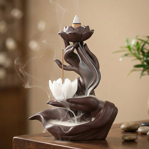 Brûleur d'encens à reflux en céramique brune en forme de main tenant un lotus blanc avec fumée en cascade